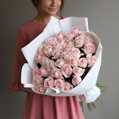 A woman is holding a bouquet with roses.